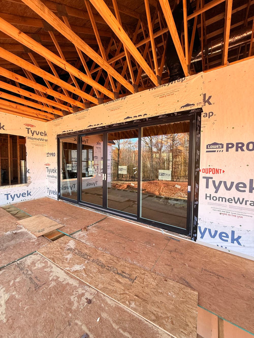 Newly framed home interior showcasing large sliding glass doors under construction.