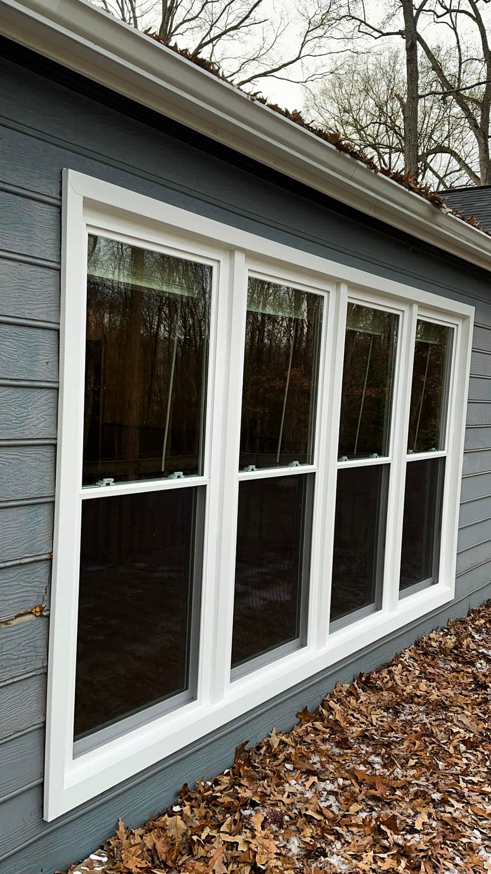 Modern home with four energy-efficient windows, surrounded by autumn leaves.